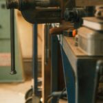 Metal vice clamped on blue workbench in an industrial workshop, perfect for machinery themes.