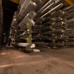 Indoor view of an industrial warehouse filled with steel pipes stored on shelves.